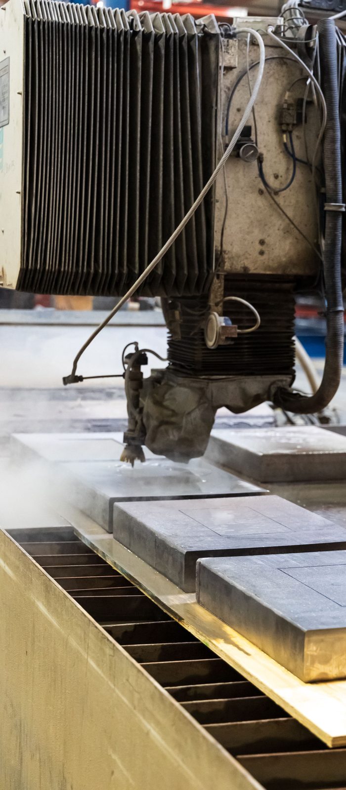 Vannskjæring av metall Vannskjæringsdyse som skjærer gjennom en metallplate
